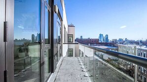 Un edificio moderno con amplios ventanales y un balcón con vistas a la ciudad.