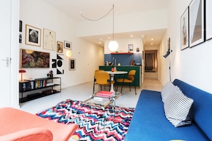 Una sala de estar moderna con un sofá, una mesa de centro y un tapete colorido.
