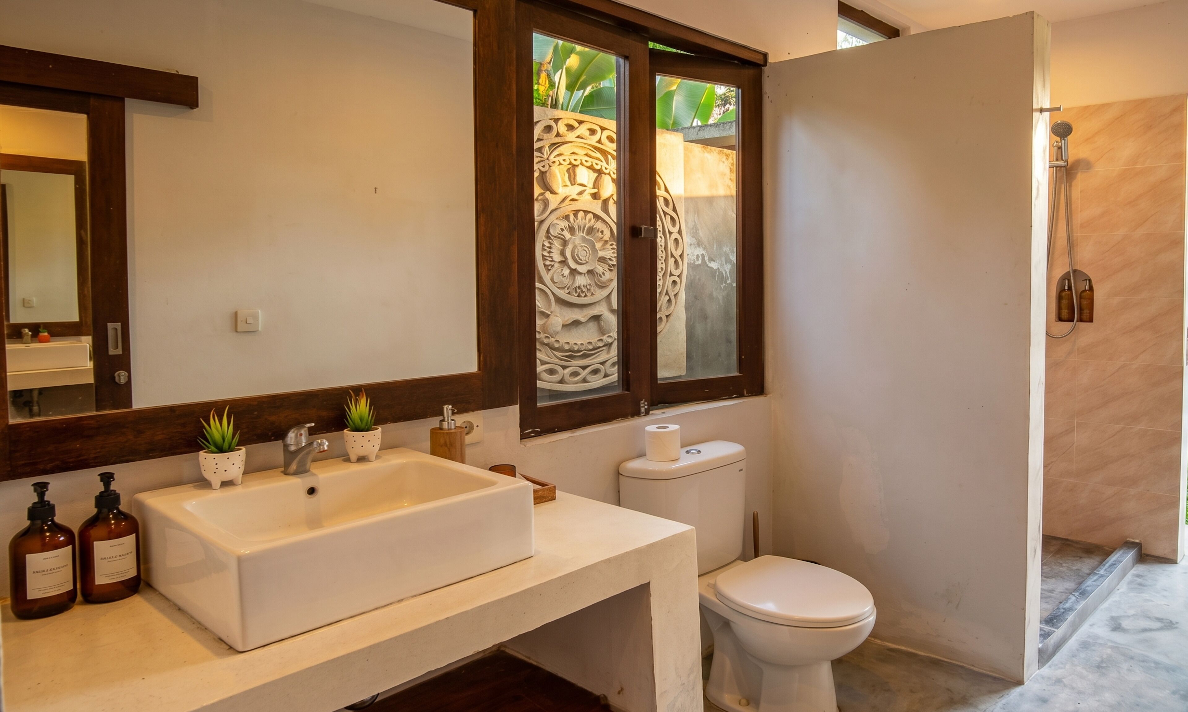 A bathroom with a large sink, toilet, and shower area.