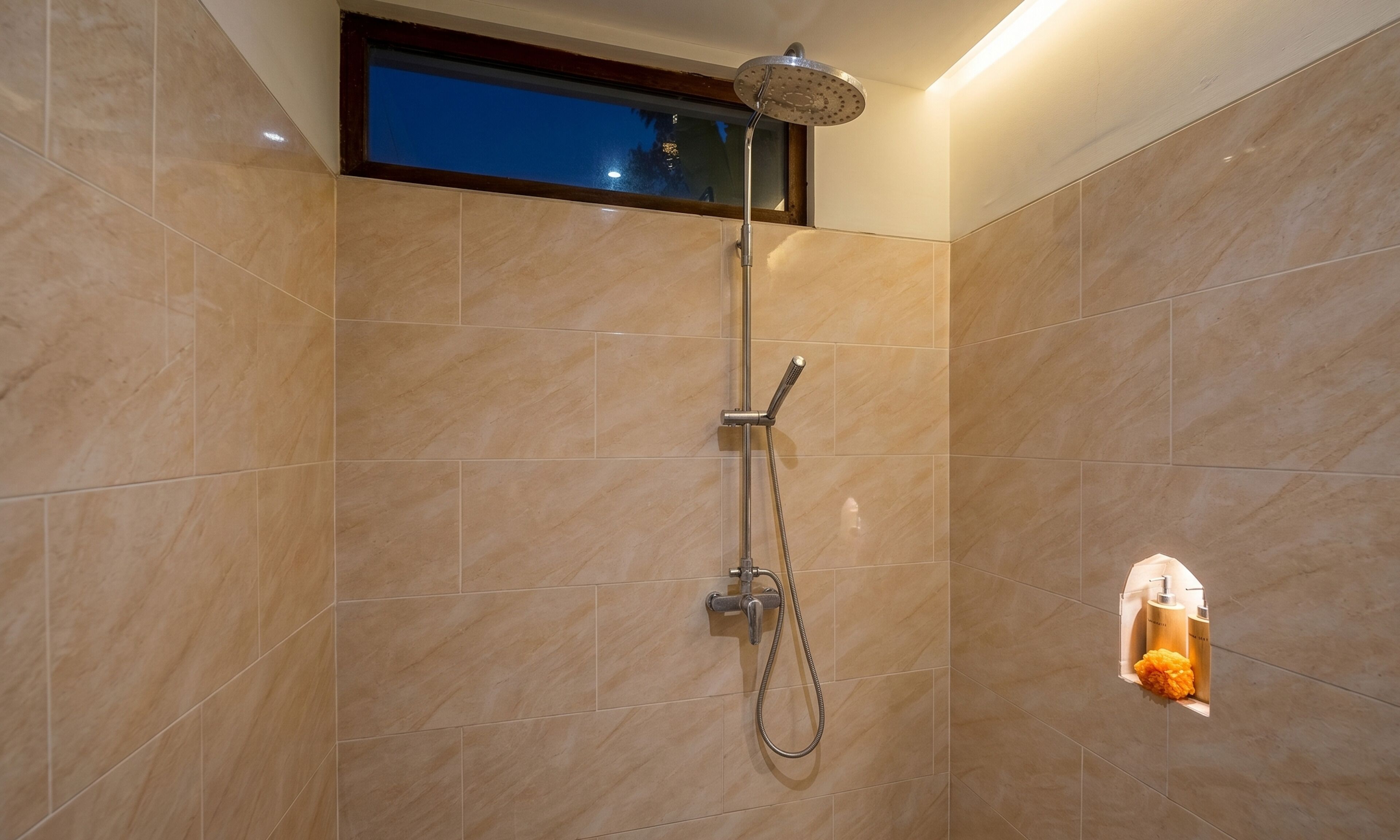 Una ducha con cabezal de ducha de mano y llave de pared.