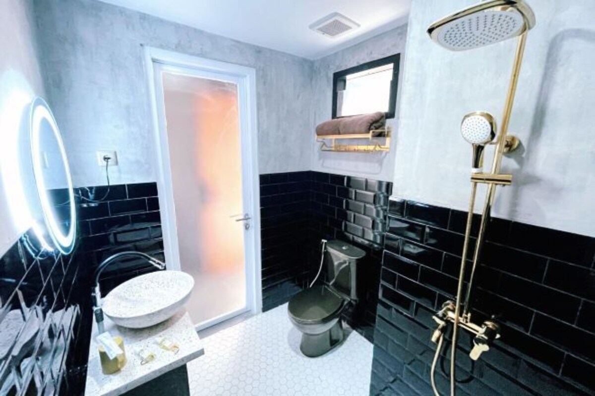Un baño de diseño moderno, con un espejo redondo, un inodoro y una ducha.