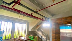 Una habitación amplia con comedor, una escalera y vistas a zonas verdes.