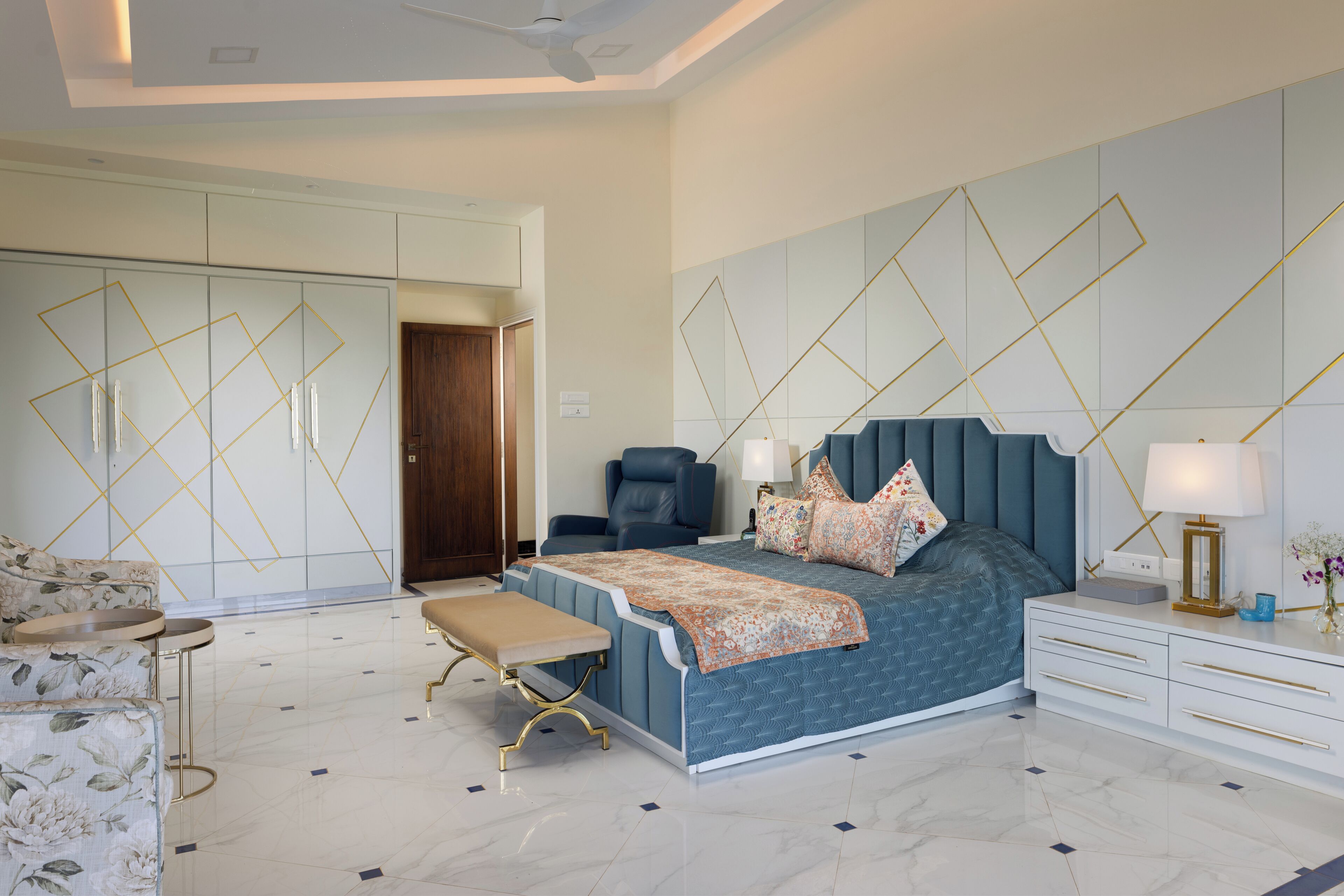 A bedroom with a bed, bedside tables, a bench, a chair, and a wardrobe.