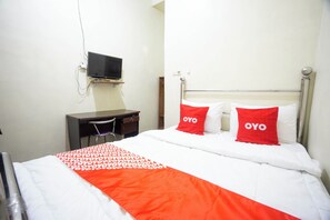 A hotel room with a bed, a desk, and a TV mounted on the wall. - OYO 93987 Suropati 2 Guest House (Malang)