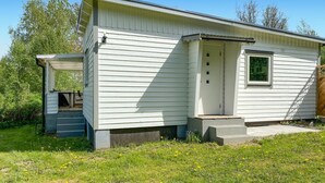 Une petite maison de plain-pied avec un porche à l’avant et une petite fenêtre.