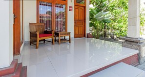 A clean, well-maintained entrance with a wooden bench and a tiled floor. - Collection O Near Seminyak Beach Formerly The Kumpi Hotel (Seminyak)