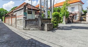 A traditional building with a tiled roof, a stone wall, and a sign that reads "Rumah House". - Collection O Near Seminyak Beach Formerly The Kumpi Hotel (Seminyak)