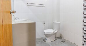 A bathroom with a toilet, sink, and a towel rack. - Collection O Near Seminyak Beach Formerly The Kumpi Hotel (Seminyak)