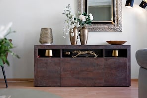 A brown wooden console with two gold vases, a decorative bowl, and a leopard figurine. - Boutique Apartment at the Castle with Wi-Fi (Bautzen)