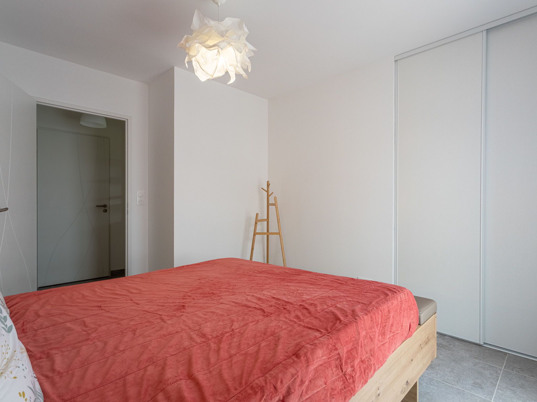 Un dormitorio con cama, escalera de madera y armario.
