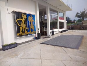 Un bâtiment sur lequel est apposée une grande enseigne représentant deux personnages et les mots « ANTASENA » et « GATOT KUCO ».