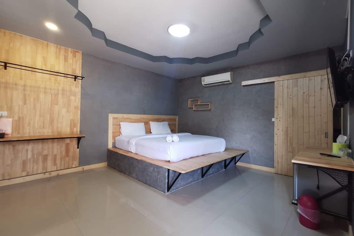 A modern bedroom with a wooden bed, a desk, and a wardrobe.