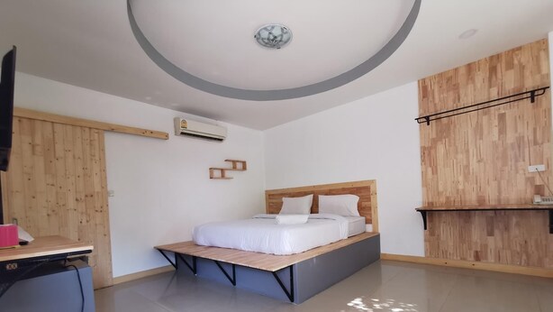 A modern bedroom with a bed, a desk, and a wardrobe. - Phatra Resort (Saraburi)