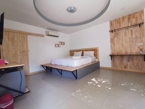 A modern bedroom with a bed, a desk, and a wardrobe. - Phatra Resort (Saraburi)