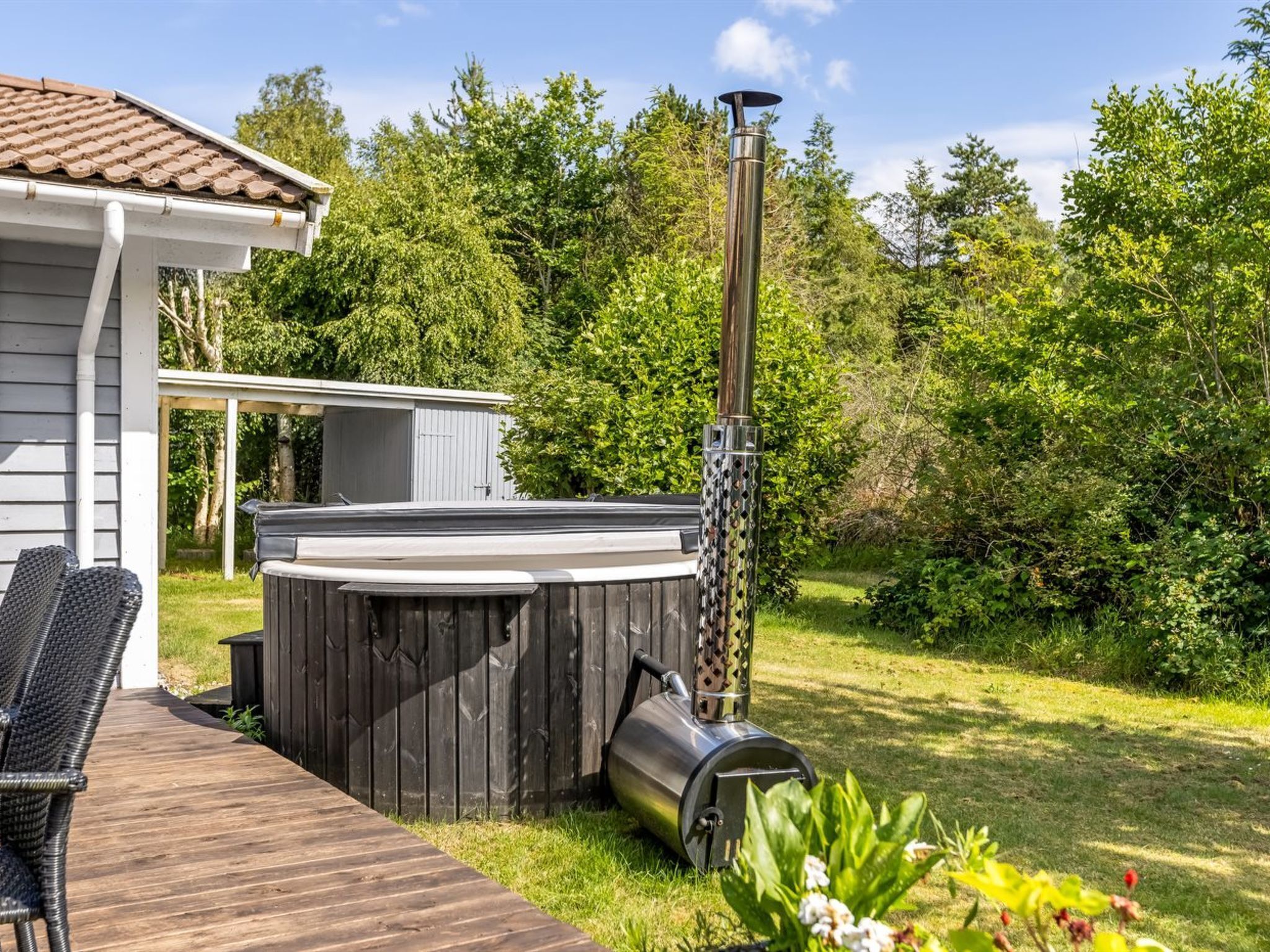 Un bain à remous avec une cheminée, une terrasse et un espace patio couvert.