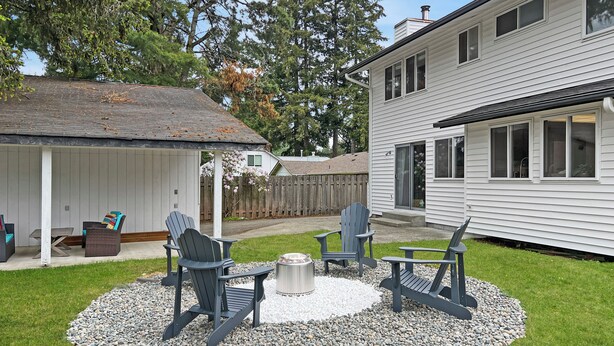 A backyard with a covered patio, outdoor seating, and a fire pit. - Entire home in Port Orchard, Washington with Game Room, Fire Pit and RV Parking (Port Orchard)