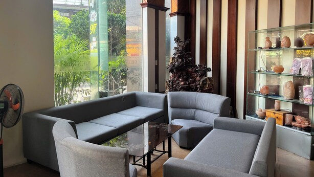 Una sala de estar moderna con sofás grises, una mesa de centro de vidrio y una escultura decorativa.
