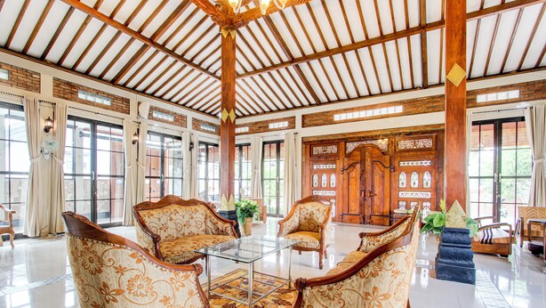 Un vestíbulo amplio con techos altos, ventanas grandes y muebles de madera tradicionales.