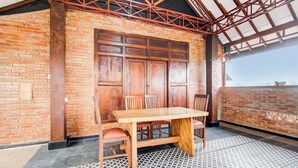 Una mesa de comedor de madera con sillas, un muro de ladrillo y un piso con diseño.