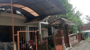 A two-story house with a covered porch and a gated entrance. - Hotel O Omah Citra Genia Homestay (Ngaglik)