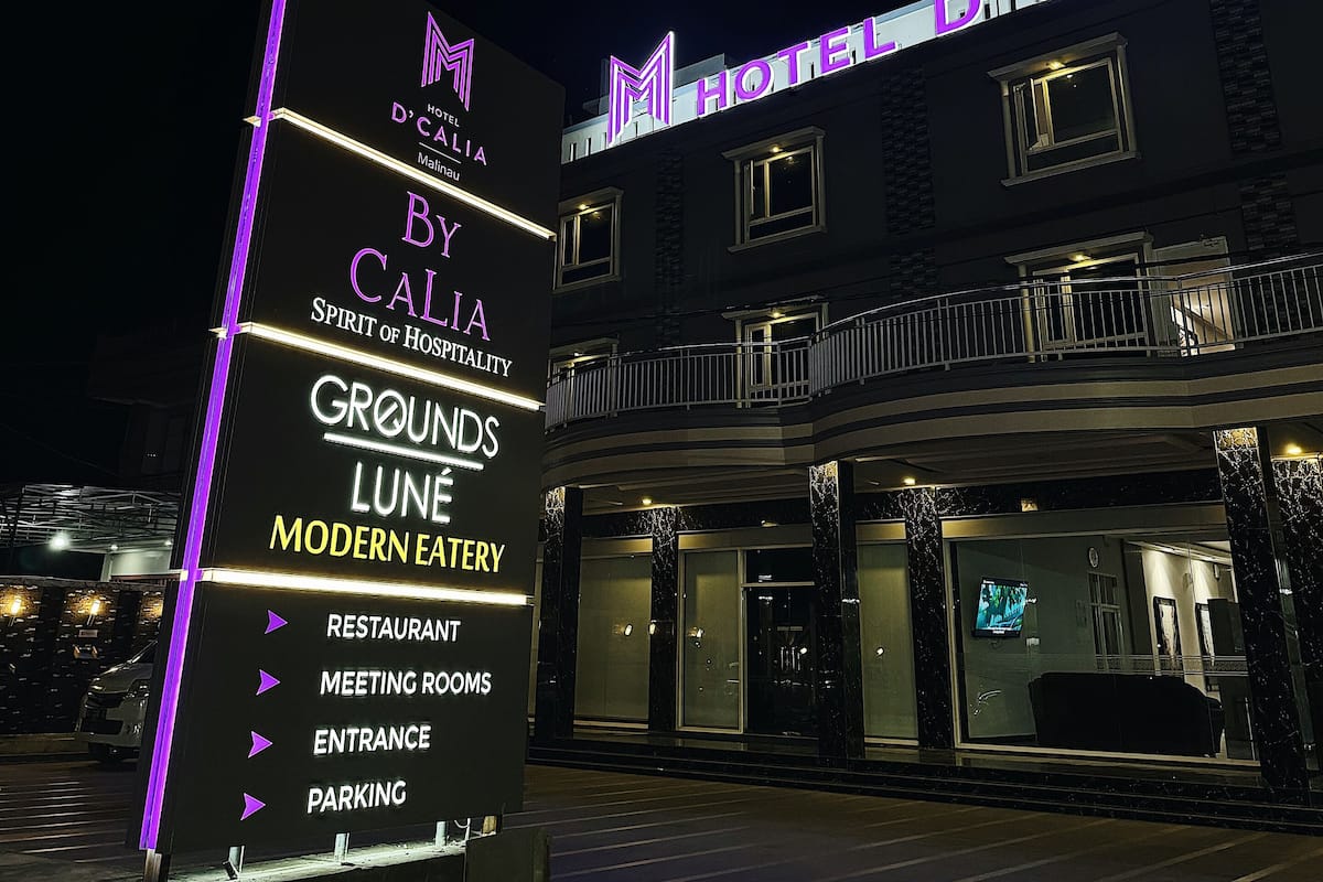Ein Hotelschild mit "Hotel D'Calia" und "Spirit of Hospitality", beleuchtet mit Neonreklame.