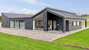 Un bâtiment moderne à deux étages, doté de grandes fenêtres et d’un toit en pente.
