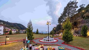 Un coin pique-nique aménagé avec une table, de la nourriture et une fontaine décorative dans un jardin paysager.