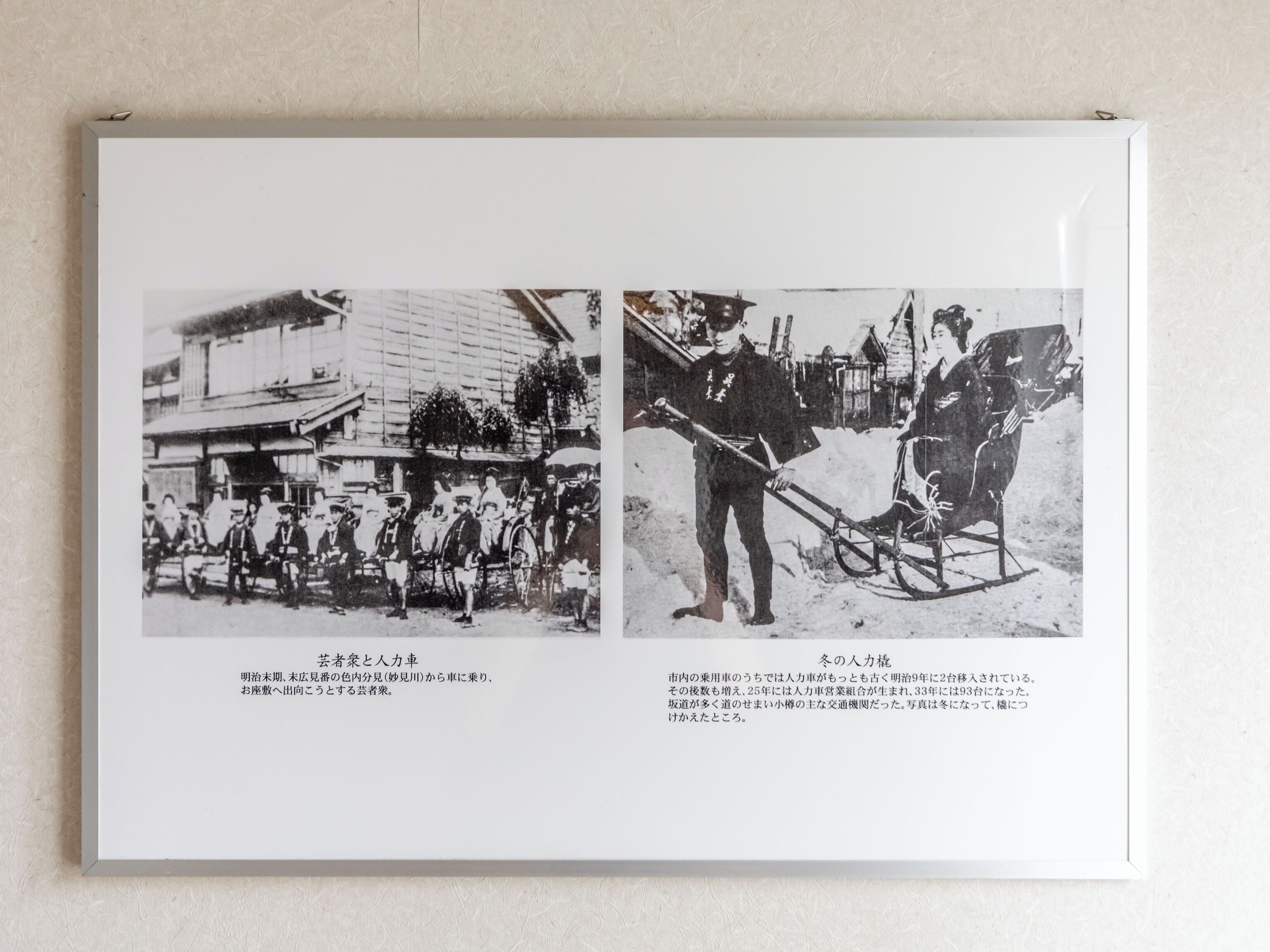 A framed historical photograph with two scenes: one of a group of people in traditional attire near a building, and another of a person pulling a sled.