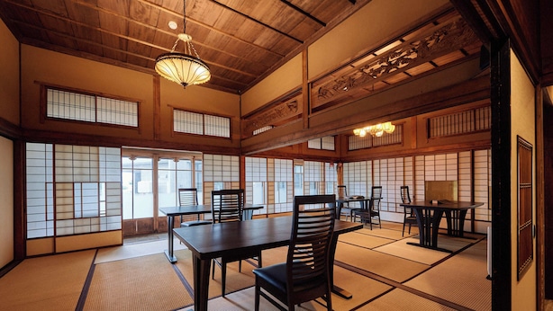 Ein traditioneller japanischer Raum mit Tatami-Böden, Holzmöbeln und Schiebetüren.