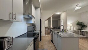 A modern kitchen with a central island, built-in appliances, and a view into the dining area. - Elegant Townhome in Prestigious Woodbridge Estate, Vaughan (Selena) (Vaughan)
