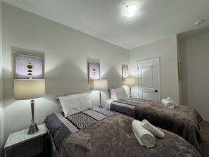 A hotel room with two beds, a nightstand, a lamp, and a door. - Elegant Townhome in Prestigious Woodbridge Estate, Vaughan (Selena) (Vaughan)