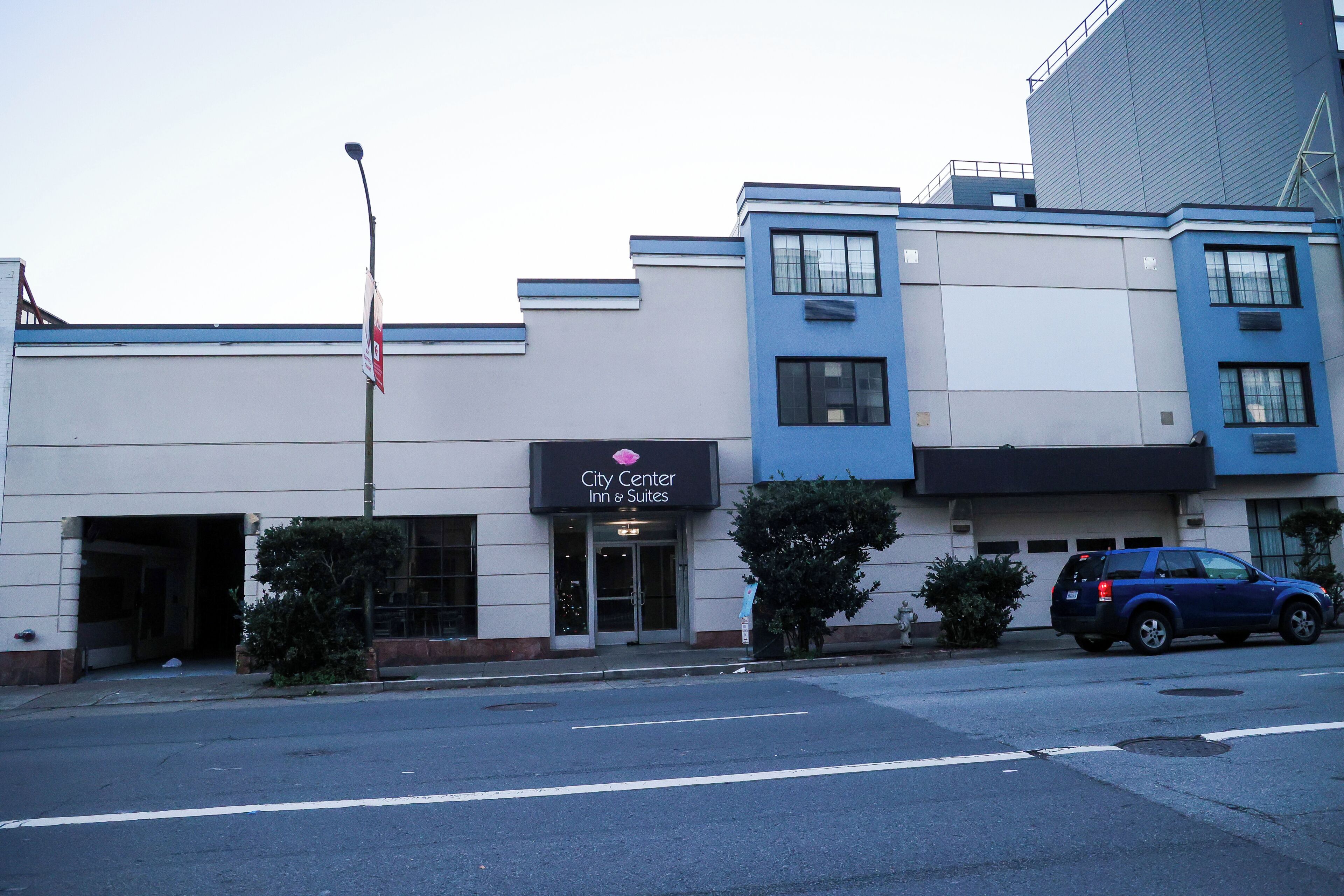 A building with a sign for 'City Center Inn & Suites' with a garage entrance.