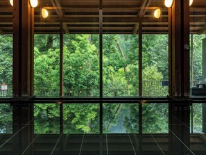 A view through large windows of a building with a wooden ceiling and metal railings. - Akigawa Valley Seoto-no-yu (Akiruno)