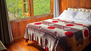 A wooden room with a bed, a window with curtains, and a chandelier. - Rancho Fernandez (Jarabacoa)