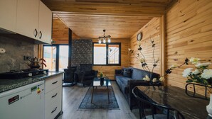 Ein gemütliches Blockhaus-Interieur mit Küche, Essbereich und Wohnzimmer.