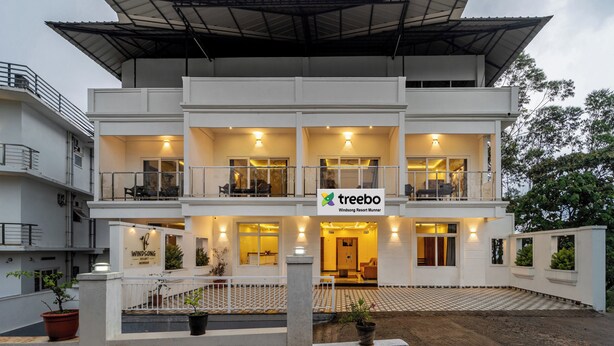 A multi-story hotel with a flat roof, balconies, and a sign for 'Treebo Windsong Resort Munar'. - Treebo Windsong Resort Munnar (Devikolam)