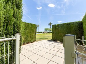 A gated entrance with a tiled pathway leading to a grassy area.