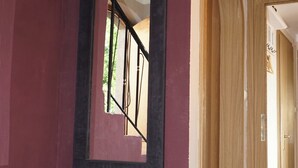 A hallway with a wooden cabinet, a large mirror, and an arched doorway. - 1 Bedroom Apartment in Lochau (Lochau)
