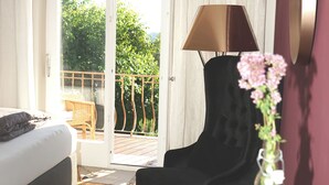 A hotel room with a bed, a desk, a chair, a lamp, and a view of the outdoors through a sliding door. - 1 Bedroom Apartment in Lochau (Lochau)