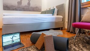 Ein modernes Schlafzimmer mit einem Bett, einem Laptop und einem Bild von Hirschen.
