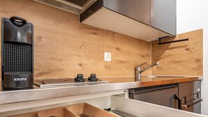Eine moderne Küche mit Holzschnitzereien, einem eingebauten Herd und einem Spülbecken.