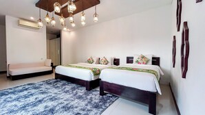 A hotel room with two beds, a sofa, a patterned rug, and a ceiling light fixture. - Kamboja Villa Umalas by Premier  (Kerobokan)