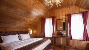 Ein Zimmer mit Holzwänden, einem Bett, einem Schreibtisch und einem Spiegel.