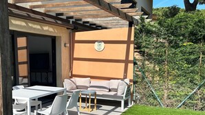 An outdoor patio with a white table and chairs, a beige sofa, and a wooden pergola. - Preciosa Casa, con Enorme Piscina en Zona Tranquila y Familiar (Sant Feliu de Guixols)
