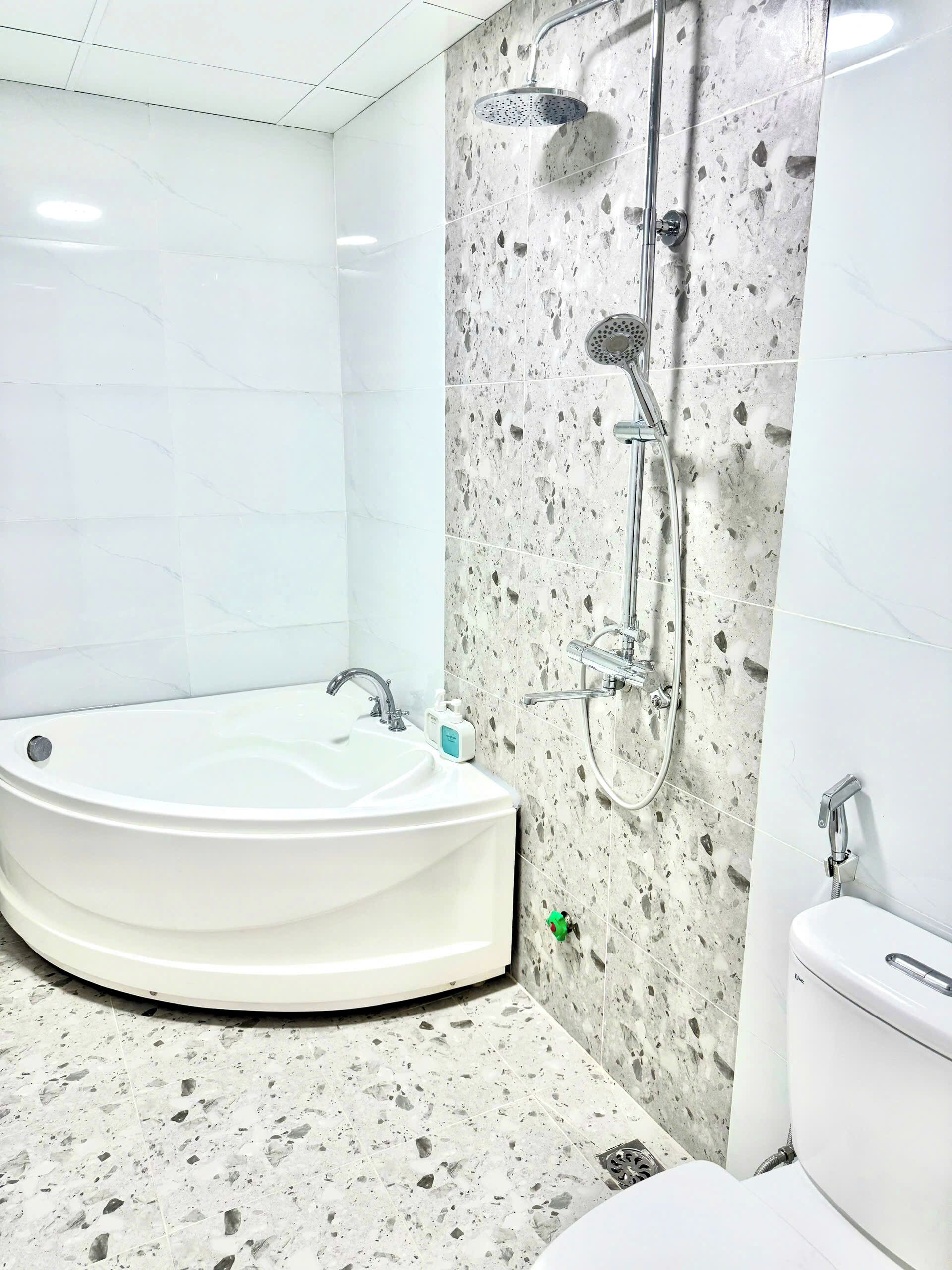 A bathroom with a freestanding bathtub, a shower, and a toilet.