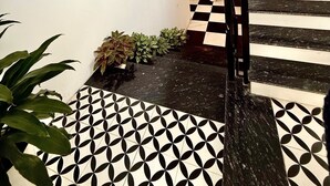 Una moderna scala con pavimento a scacchi bianchi e neri che conduce a un secondo piano.