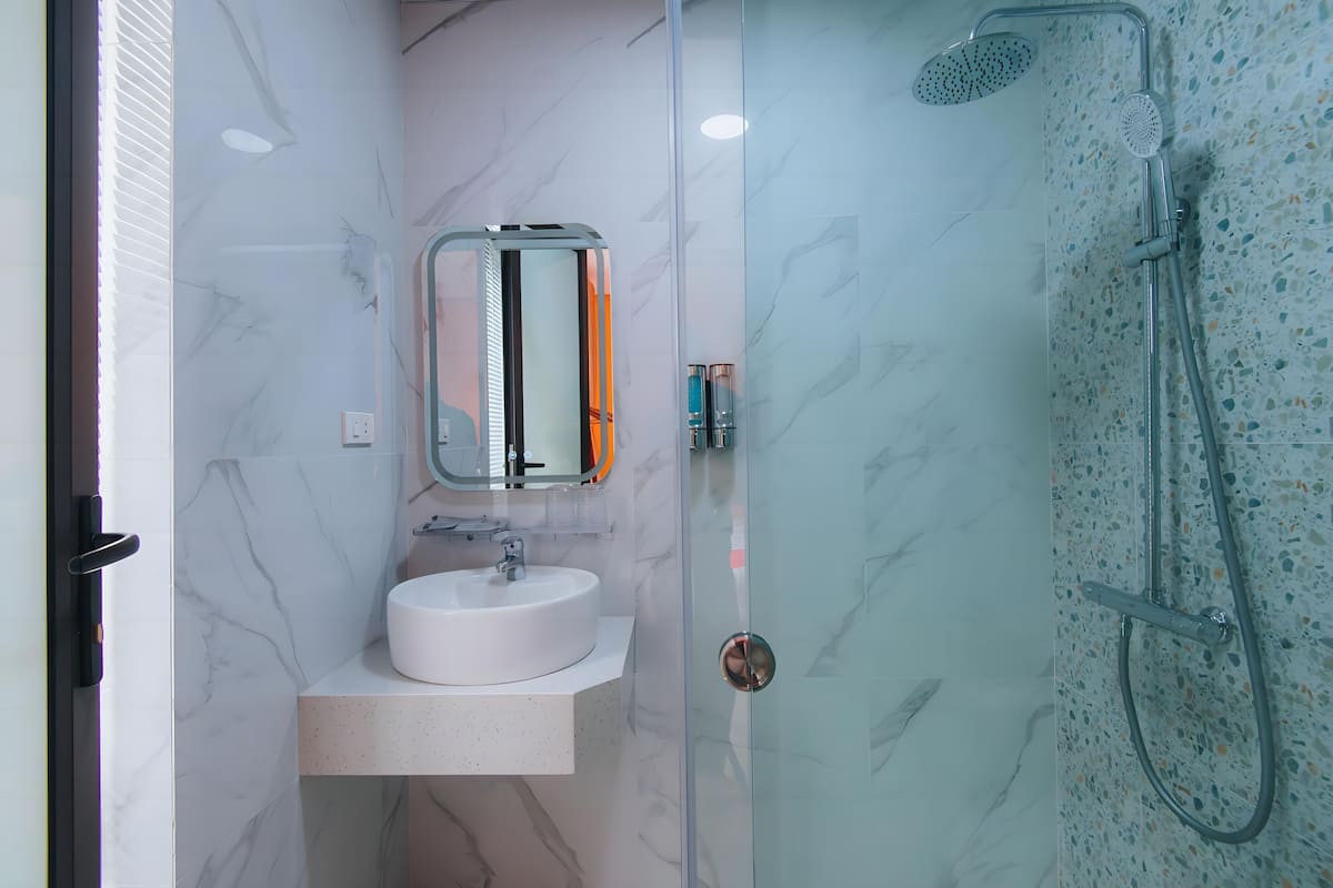 Standaard tweepersoonskamer | Badkamer | Een bad/douchecombinatie, een regendouche, designer toiletartikelen