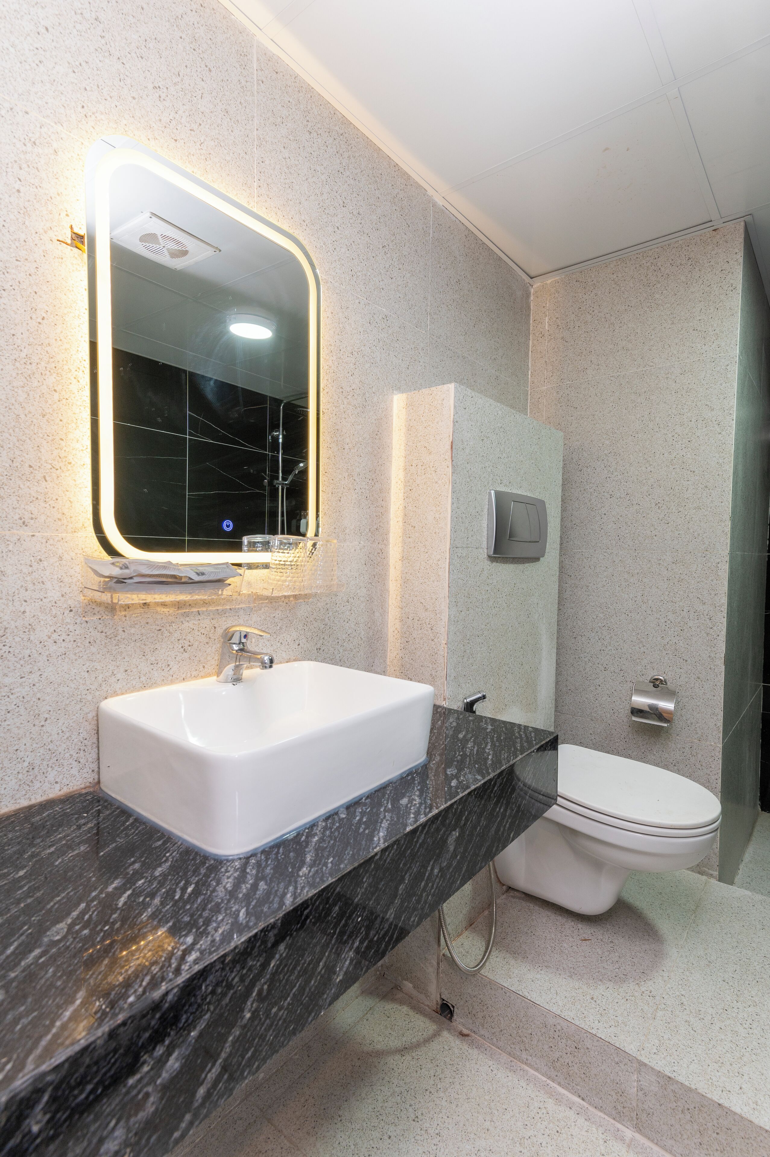 Un baño con lavamanos blanco, un espejo y un inodoro.