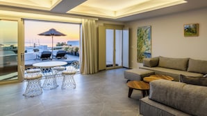 Una sala de estar moderna con un sofá, una mesa de comedor con sillas y vistas al exterior.