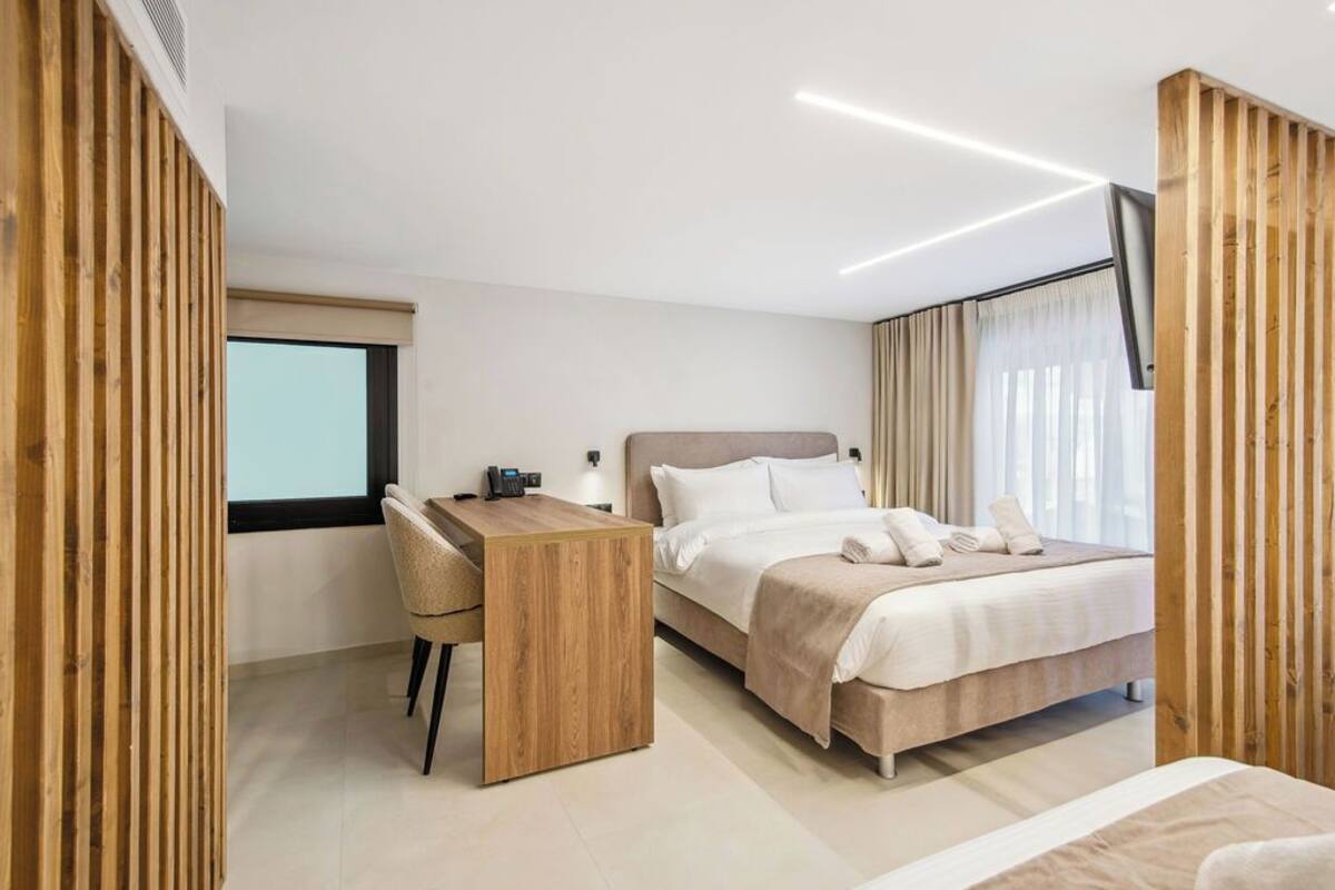 Een moderne hotelkamer met een bed, een bureau en een stoel.